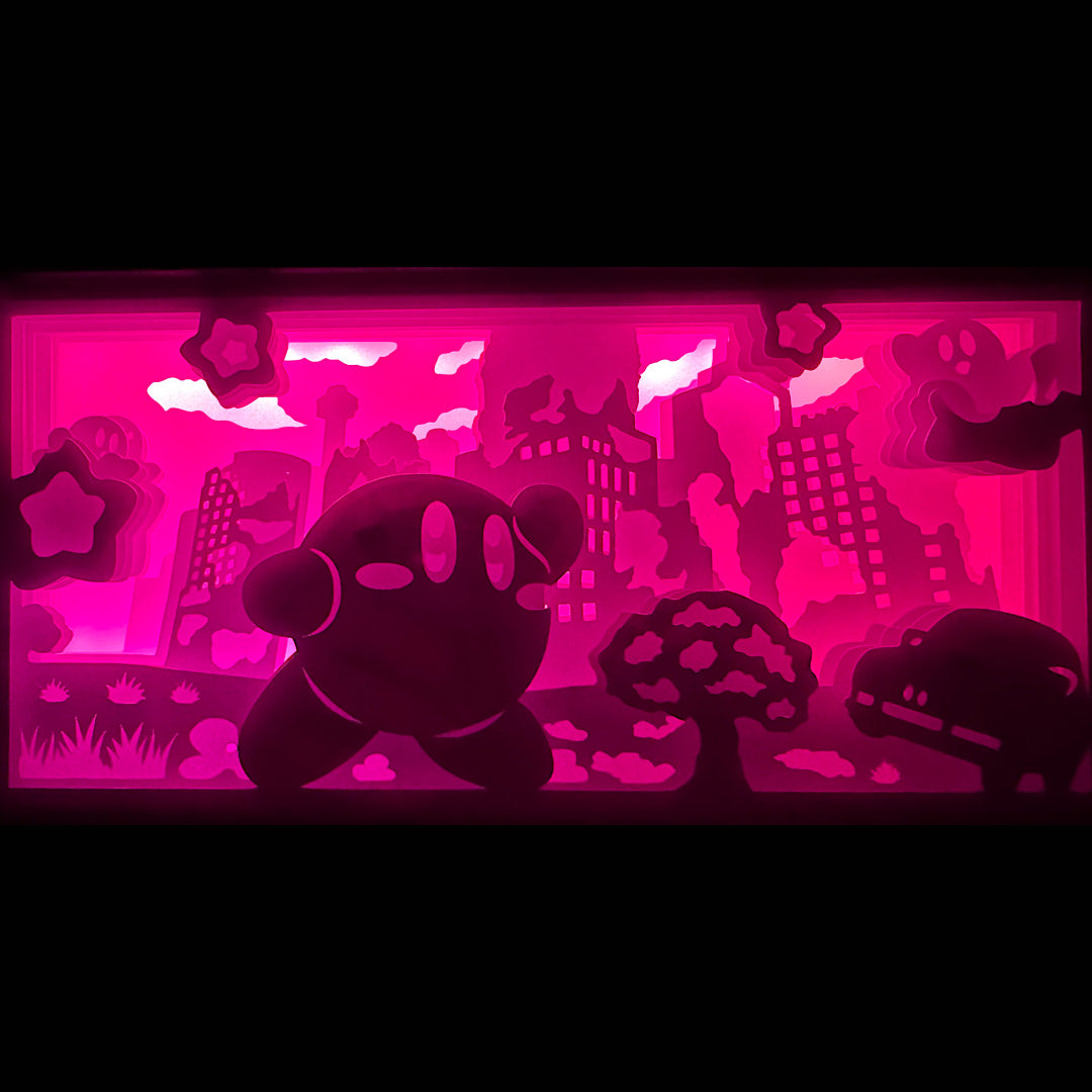 Kirby, Nintendo, HAL Laboratory, jeu vidéo culte, boule rose, Dream Land, Planet Popstar, Super Smash Bros, Roi Dadidou, Meta Knight, Waddle Dee, univers coloré, jeu plateforme, aventure mignonne, personnage emblématique Nintendo, héros adorable, pouvoir d’absorption, étoile volante, jeu rétro, saga culte, tableau lumineux, lightbox, shadowbox, cadre lumineux, papier découpé, art lumineux, décoration murale, idée cadeau gamer, déco geek