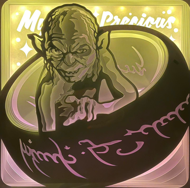 Gollum, Sméagol, Seigneur des Anneaux, Lord of the Rings, J.R.R. Tolkien, Le Hobbit, personnage culte, anneau unique, précieux, créature mystérieuse, univers fantasy, saga culte, Peter Jackson, film Le Seigneur des Anneaux, monde de la Terre du Milieu, sombre et tragique, tableau lumineux, lightbox, shadowbox, cadre lumineux, papier découpé, art lumineux, décoration murale, idée cadeau geek, déco fantasy, cadeau fan Tolkien