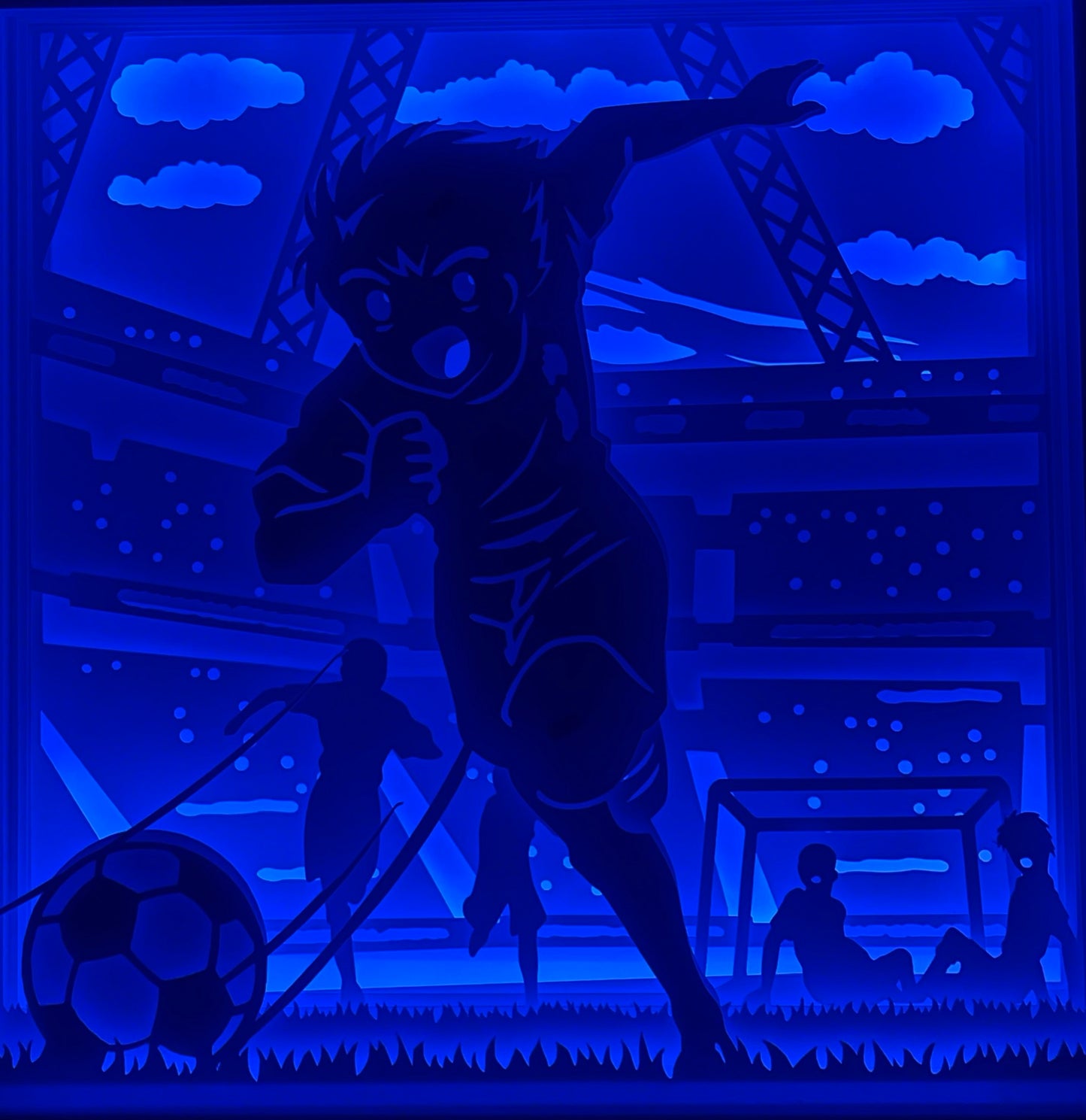 Tsubasa, Captain Tsubasa, Olive et Tom, manga football, anime culte, match de foot, joueur de foot manga, ballon de football, sport japonais, série animée, personnage culte, tableau lumineux Tsubasa, lightbox manga foot, shadowbox football, papier découpé, décoration murale manga, idée cadeau sportif, déco geek football, cadre lumineux Olive et Tom, art lumineux Tsubasa