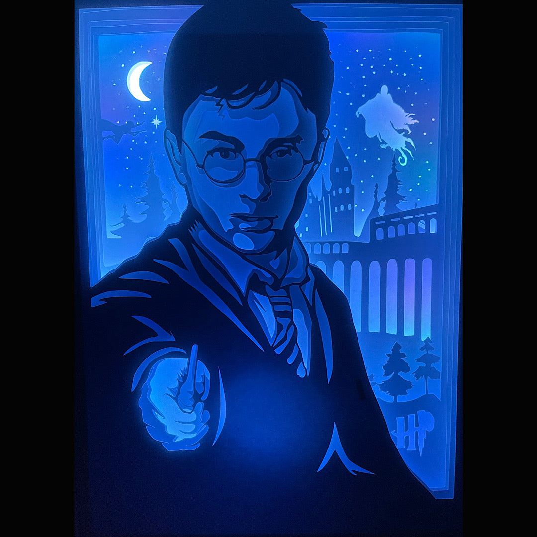 Harry Potter, J.K. Rowling, Poudlard, Hogwarts, Gryffondor, Serpentard, Poufsouffle, Serdaigle, Hedwige, Dobby, baguette magique, Patronus, Quidditch, magie, sorcier, univers fantastique, saga Harry Potter, film culte, Warner Bros, château de Poudlard, école des sorciers, tableau lumineux, lightbox, shadowbox, cadre lumineux, papier découpé, art lumineux, décoration murale, idée cadeau geek, déco fantastique, cadeau fan Harry Potter