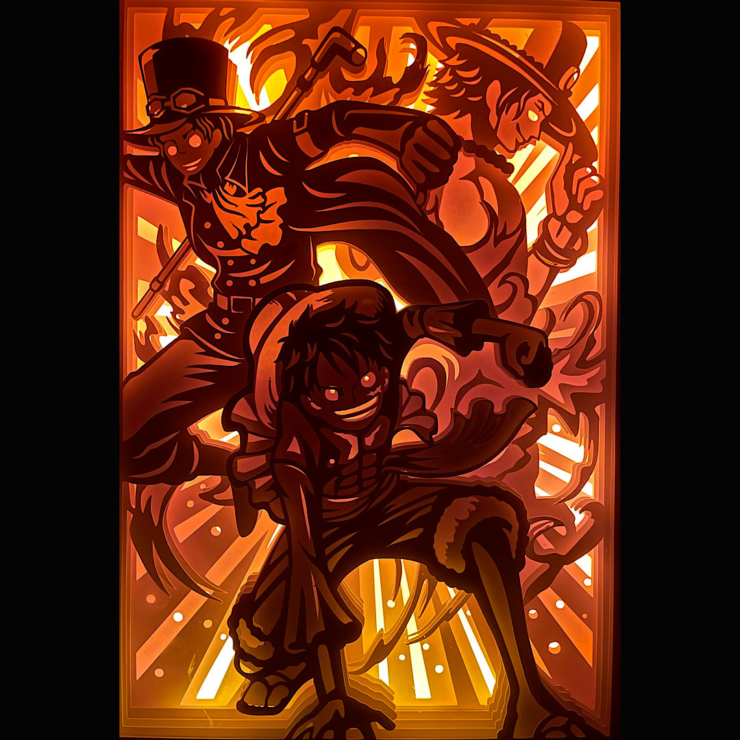 One Piece, Eiichiro Oda, manga culte, anime culte, Luffy, Ace, Sabo, frères jurés, Mugiwara, équipage du chapeau de paille, pirate au chapeau de paille, Portgas D. Ace, pouvoir du feu, fruit du démon Mera Mera no Mi, Révolutionnaires, Grand Line, Nouveau Monde, amitié fraternelle, saga One Piece, combat épique, univers fantastique, tableau lumineux, lightbox, shadowbox, cadre lumineux, papier découpé, art lumineux, décoration murale, idée cadeau manga, déco geek, cadeau otaku