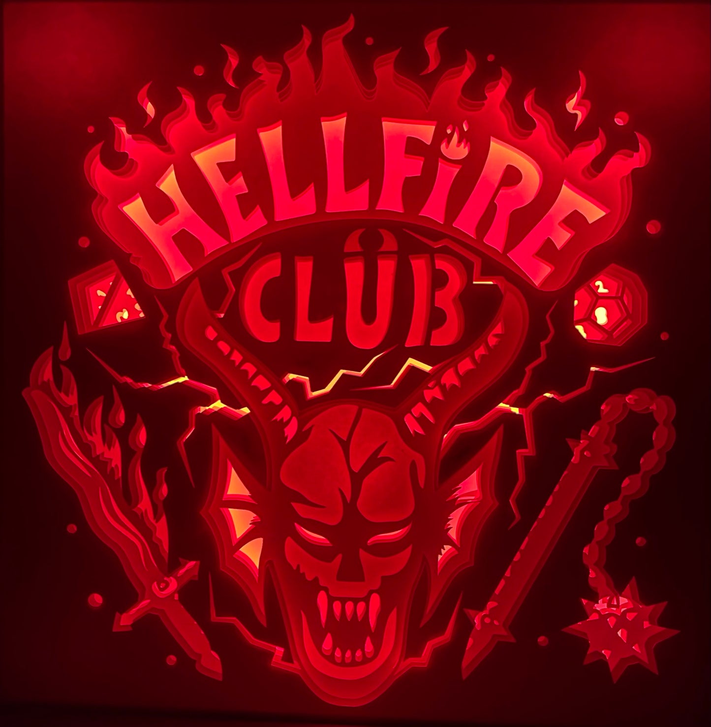 Hellfire Club, Stranger Things, Netflix, Donjons et Dragons, Dungeons and Dragons, Eddie Munson, Hawkins High, club de jeu de rôle, années 80, saison 4 Stranger Things, univers fantastique, Upside Down, monde à l’envers, Vecna, série culte, geek culture, parties de D&D, équipe Hawkins, Demogorgon, aventure épique, tableau lumineux, lightbox, shadowbox, cadre lumineux, papier découpé, art lumineux, décoration murale, idée cadeau geek, déco série TV, cadeau fan Stranger Things