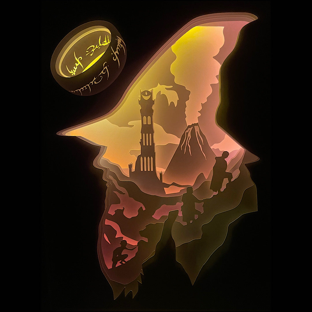 Le Seigneur des Anneaux, Lord of the Rings, J.R.R. Tolkien, Frodon, Gandalf, Aragorn, Legolas, Gimli, Sam, Gollum, Sauron, anneau unique, communauté de l’anneau, univers fantasy, Terre du Milieu, film culte, trilogie Peter Jackson, bataille épique, Mordor, comté, saga culte, héros légendaires, tableau lumineux, lightbox, shadowbox, cadre lumineux, papier découpé, art lumineux, décoration murale, idée cadeau geek, déco fantasy, cadeau fan Tolkien