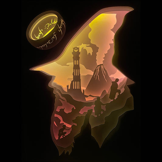 Le Seigneur des Anneaux, Lord of the Rings, J.R.R. Tolkien, Frodon, Gandalf, Aragorn, Legolas, Gimli, Sam, Gollum, Sauron, anneau unique, communauté de l’anneau, univers fantasy, Terre du Milieu, film culte, trilogie Peter Jackson, bataille épique, Mordor, comté, saga culte, héros légendaires, tableau lumineux, lightbox, shadowbox, cadre lumineux, papier découpé, art lumineux, décoration murale, idée cadeau geek, déco fantasy, cadeau fan Tolkien