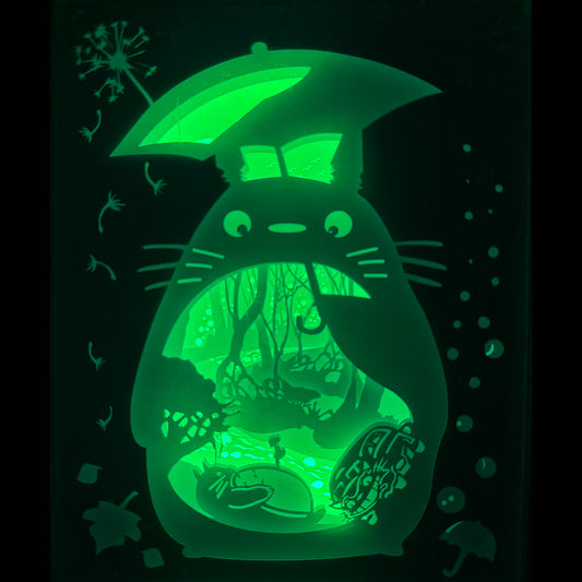 Totoro, Mon Voisin Totoro, Studio Ghibli, Hayao Miyazaki, esprit de la forêt, forêt magique, parapluie Totoro, créatures fantastiques, univers Ghibli, anime japonais, film d’animation culte, nature enchantée, noiraudes, Chatbus, décor japonais, tableau lumineux Totoro, lightbox Ghibli, shadowbox Totoro, cadre lumineux anime, papier découpé, décoration geek, art lumineux japonais, idée cadeau Ghibli, ambiance féerique