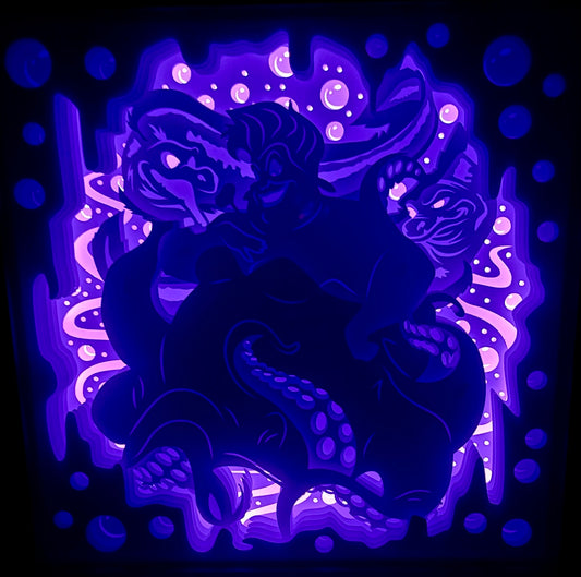 Ursula, Disney, La Petite Sirène, The Little Mermaid, sorcière des mers, méchante Disney, Ariel, roi Triton, Polochon, prince Éric, tentacules, magie noire, contrat magique, voix d’Ariel, univers marin, Atlantica, film d’animation culte, personnage emblématique, méchante culte, tableau lumineux, lightbox, shadowbox, cadre lumineux, papier découpé, art lumineux, décoration murale, idée cadeau Disney, déco geek, cadeau fan Disney