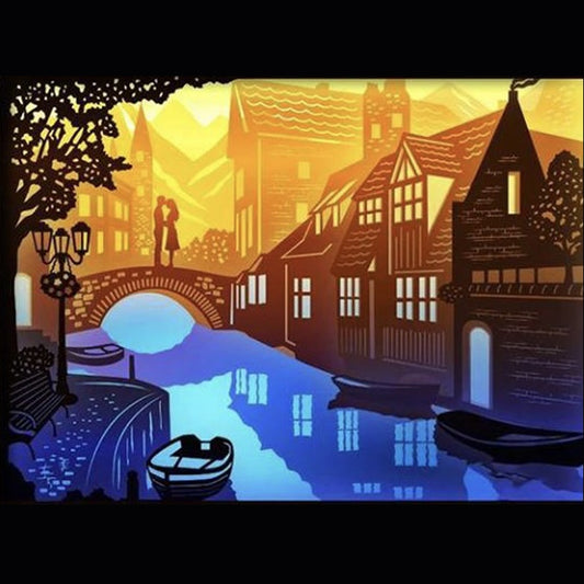 ville au bord de l’eau, paysage urbain, fleuve, rivière, pont illuminé, maisons au bord du fleuve, coucher de soleil sur l’eau, reflets lumineux, cadre lumineux ville, tableau lumineux décoratif, lightbox paysage, shadowbox rivière, décoration murale, papier découpé, idée cadeau maison, ambiance romantique, art lumineux urbain